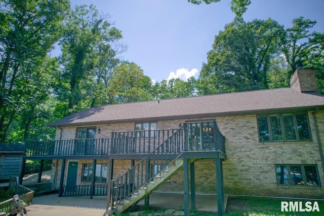 12299 Pebble Point Rd, Marion, IL 62959 - rear view of property featuring brick siding, a deck, a chimney, stairway, and a patio