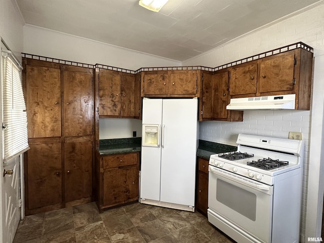 1520 Gartside St, Murphysboro, IL 62966 - kitchen featuring white appliances, under cabinet range hood, ornamental molding, dark countertops, and stone finish floors