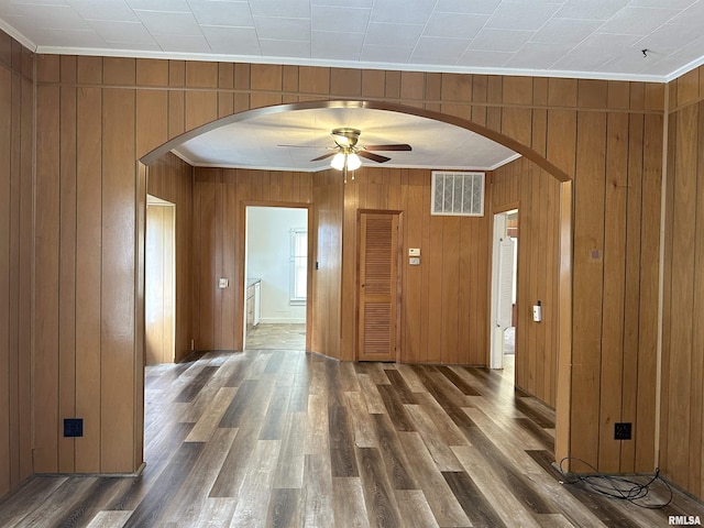 1520 Gartside St, Murphysboro, IL 62966 - spare room with arched walkways, ornamental molding, a ceiling fan, wood walls, and wood finished floors