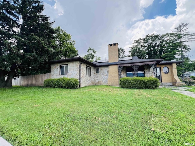 385 3rd St, Omaha, IL 62871 - back of house featuring a chimney, stone siding, and solar panels
