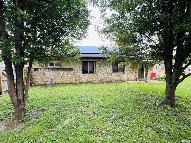 385 3rd St, Omaha, IL 62871 - view of front of house with stone siding and roof mounted solar panels