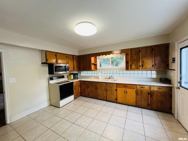 385 3rd St, Omaha, IL 62871 - kitchen featuring electric stove, stainless steel microwave, light countertops, and brown cabinets