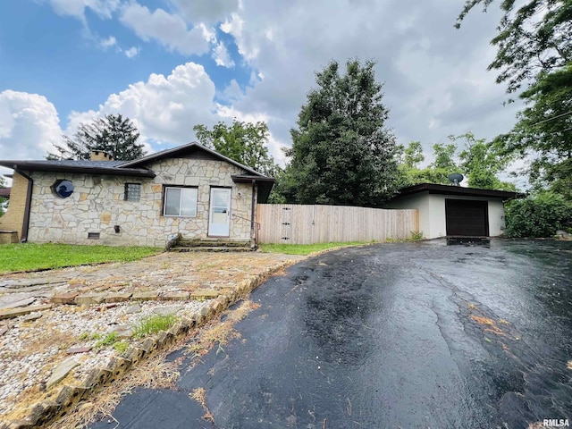 385 3rd St, Omaha, IL 62871 - view of front of property featuring stone siding, asphalt driveway, a garage, and a chimney
