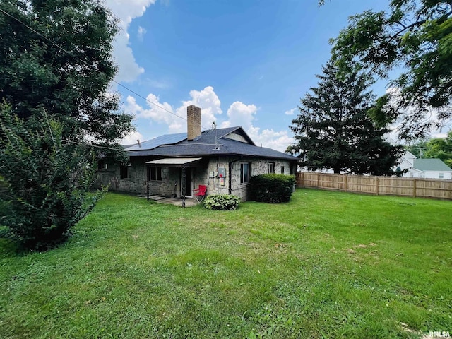 385 3rd St, Omaha, IL 62871 - rear view of property with solar panels, stone siding, and a chimney