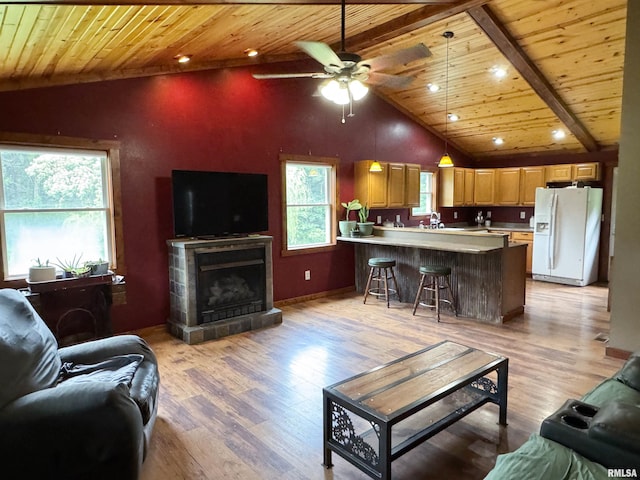 339 Spring St, Dongola, IL 62926 - living area featuring a wooden ceiling with exposed beams, ceiling fan, light wood-style flooring, a tiled fireplace, and high vaulted ceiling
