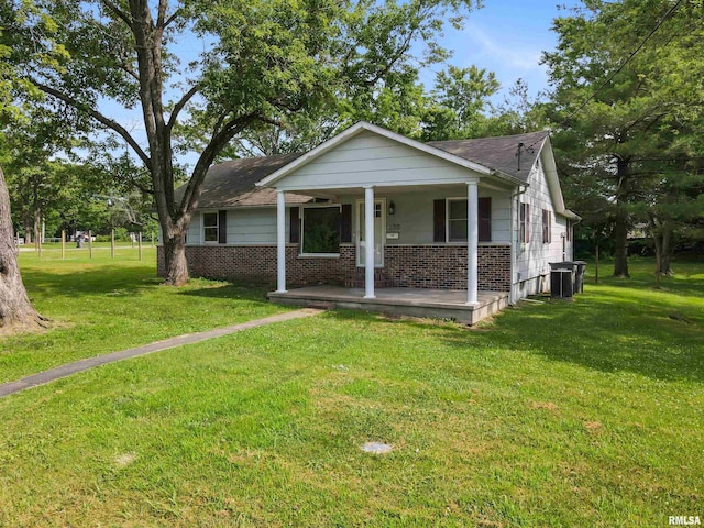 1130 W Webster St, Benton, IL 62812 - bungalow-style home with a porch, a front yard, brick siding, and a shingled roof