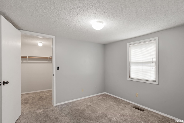 1130 W Webster St, Benton, IL 62812 - unfurnished bedroom with a spacious closet, carpet flooring, a textured ceiling, and a closet
