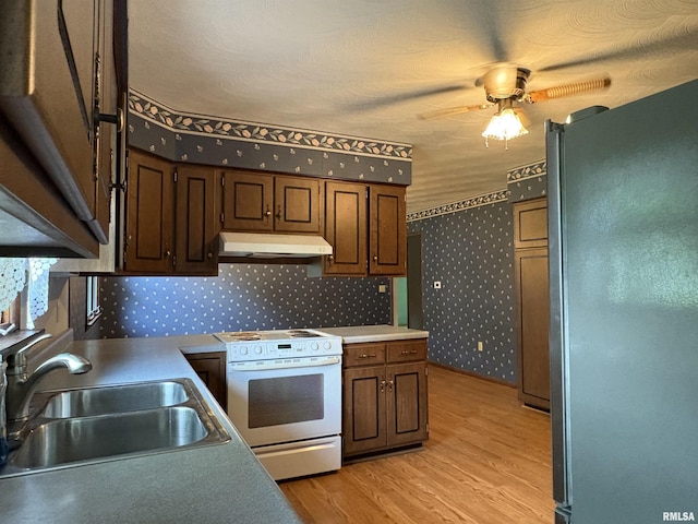 822 N 24th St, Murphysboro, IL 62966 - kitchen featuring freestanding refrigerator, white range with electric stovetop, under cabinet range hood, wallpapered walls, and ceiling fan