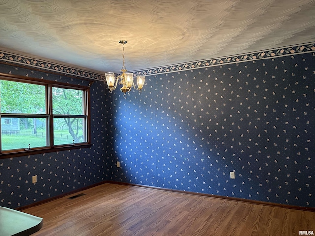 822 N 24th St, Murphysboro, IL 62966 - unfurnished dining area with wood finished floors, wallpapered walls, and a chandelier