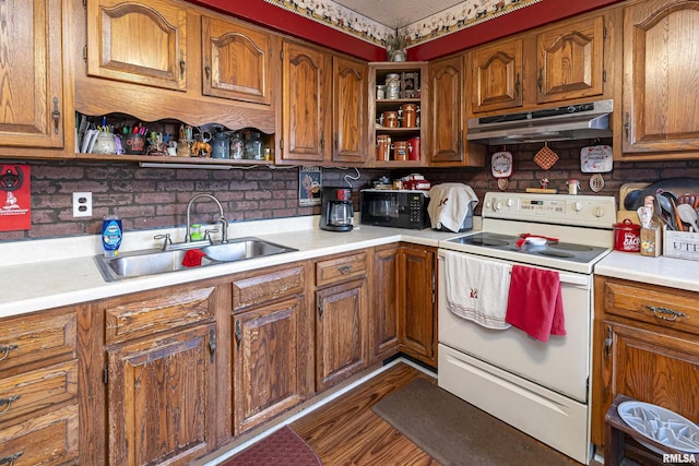 402 S Clay St, Sesser, IL 62884 - kitchen with electric range, open shelves, under cabinet range hood, light countertops, and brown cabinetry