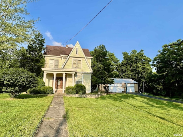 850 Joppa N Ave, Joppa, IL 62953 - view of front facade with a front yard, a garage, an outdoor structure, and a chimney