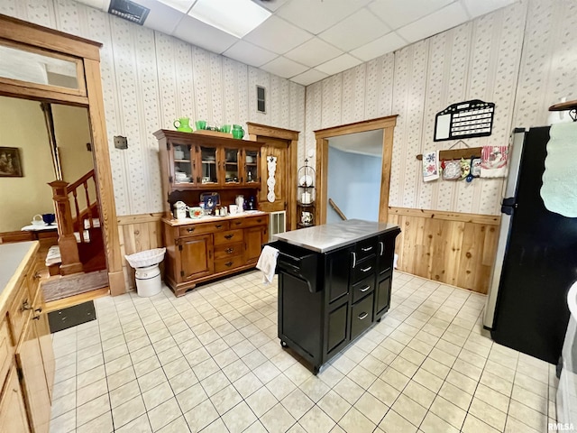 850 Joppa N Ave, Joppa, IL 62953 - kitchen with freestanding refrigerator, dark cabinets, a wainscoted wall, light countertops, and light tile patterned floors