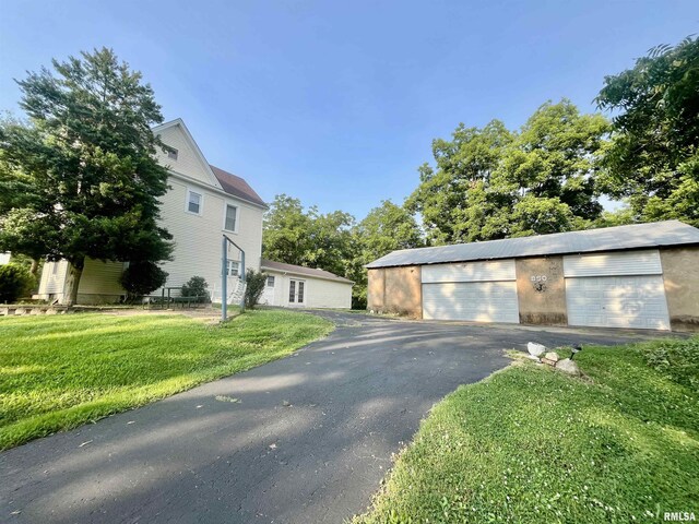 850 Joppa N Ave, Joppa, IL 62953 - view of property exterior featuring a garage, a yard, and an outbuilding