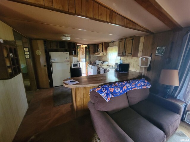 1060 W 5th St, Flora, IL 62839 - kitchen with white appliances, lofted ceiling, a peninsula, and wooden walls