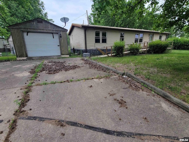 1060 W 5th St, Flora, IL 62839 - manufactured / mobile home with driveway, an outdoor structure, a detached garage, and a front yard
