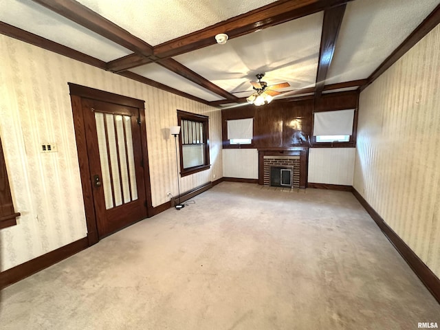 321 S Maple St, Centralia, IL 62801 - unfurnished living room with wallpapered walls, a brick fireplace, ceiling fan, beam ceiling, and carpet