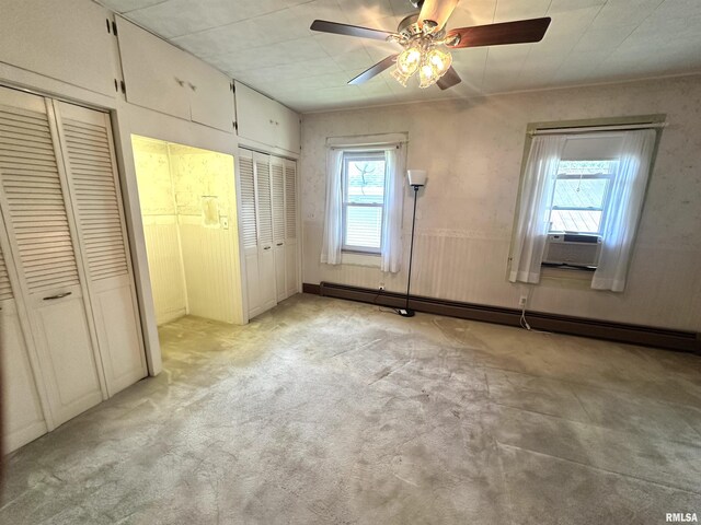 321 S Maple St, Centralia, IL 62801 - unfurnished bedroom featuring baseboard heating, two closets, light colored carpet, cooling unit, and ceiling fan