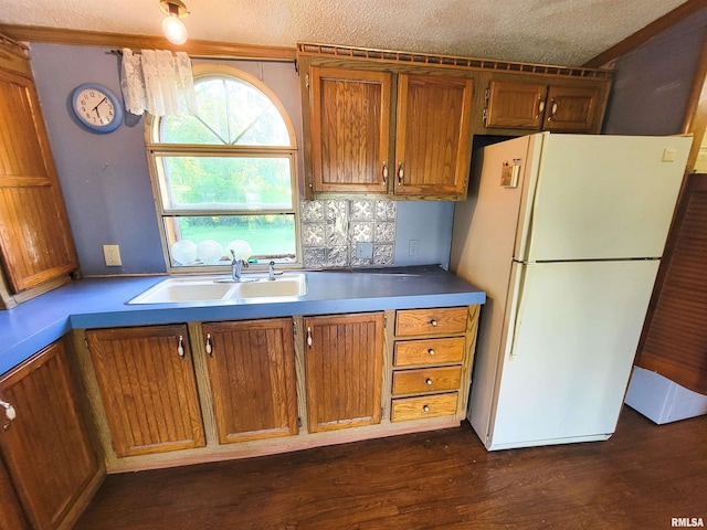 235 W 8th St, Flora, IL 62839 - kitchen with freestanding refrigerator, brown cabinets, a textured ceiling, dark wood-style flooring, and tasteful backsplash