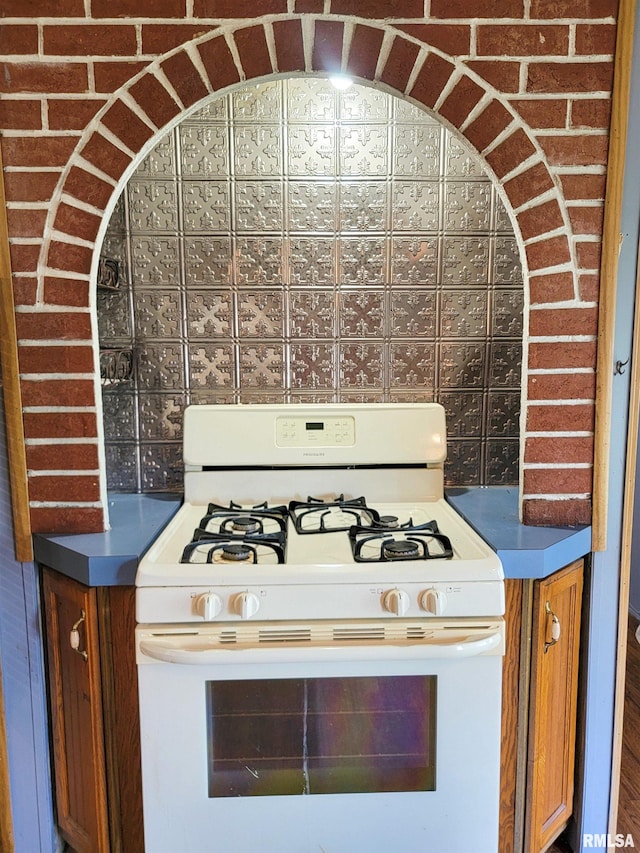 235 W 8th St, Flora, IL 62839 - kitchen view of white gas range oven and brown cabinetry