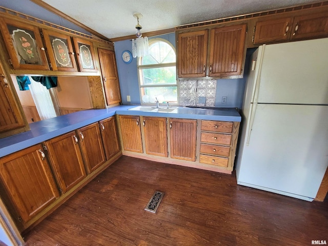 235 W 8th St, Flora, IL 62839 - kitchen featuring freestanding refrigerator, ornamental molding, dark wood finished floors, brown cabinets, and glass insert cabinets