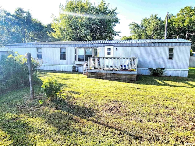 235 W 8th St, Flora, IL 62839 - back of house featuring a lawn, a wooden deck, and a metal roof