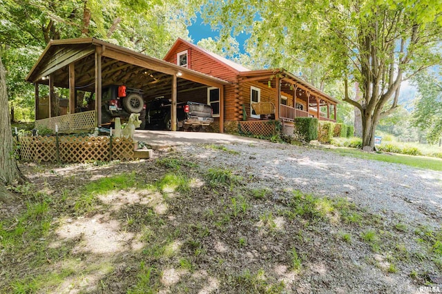 690 Ganntown Ln, Grantsburg, IL 62943 - rear view of house with driveway, log siding, and a carport