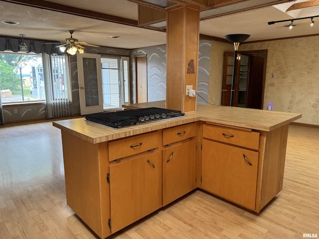 3100 Ava Rd, Murphysboro, IL 62994 - kitchen with stainless steel gas stovetop, light wood-style flooring, a peninsula, wallpapered walls, and a ceiling fan