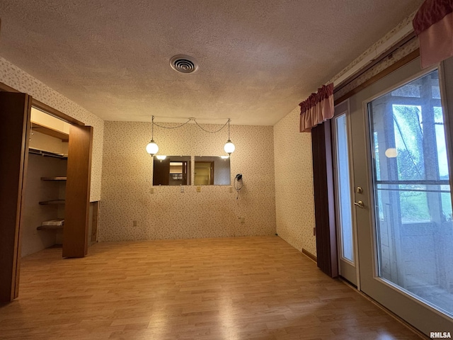 3100 Ava Rd, Murphysboro, IL 62994 - spare room with a textured ceiling, wood finished floors, wallpapered walls, and healthy amount of natural light