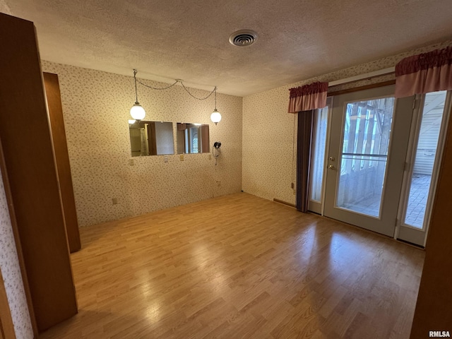 3100 Ava Rd, Murphysboro, IL 62994 - spare room featuring wallpapered walls, a textured ceiling, and wood finished floors