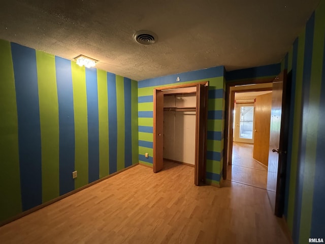 3100 Ava Rd, Murphysboro, IL 62994 - unfurnished bedroom featuring wood finished floors, a textured ceiling, and wallpapered walls