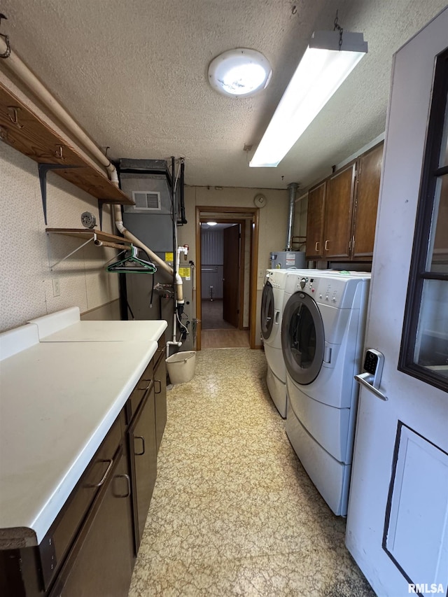 3100 Ava Rd, Murphysboro, IL 62994 - laundry area featuring cabinet space, washing machine and clothes dryer, a textured ceiling, and light floors