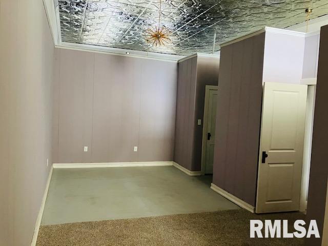 6 S Division St, Duquoin, IL 62832 - carpeted empty room with baseboards and an ornate ceiling