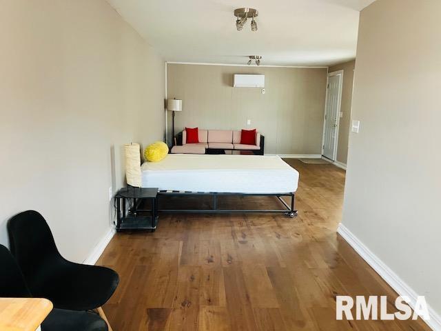 6 S Division St, Duquoin, IL 62832 - bedroom with wood finished floors and a wall unit AC