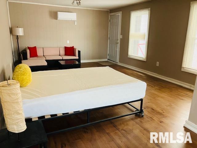 6 S Division St, Duquoin, IL 62832 - bedroom with wood finished floors and a wall mounted AC