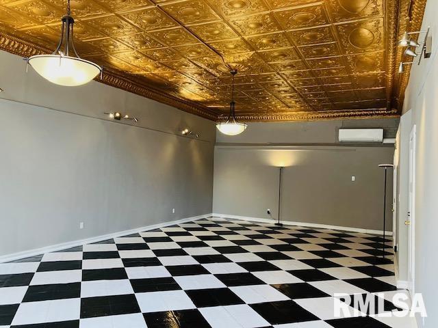 6 S Division St, Duquoin, IL 62832 - empty room with a wall unit AC, tile patterned floors, and an ornate ceiling