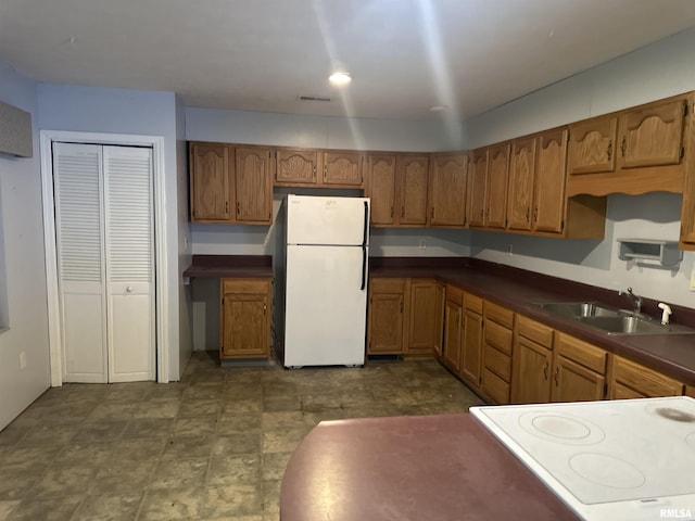 104 Mcneil St, Energy, IL 62933 - kitchen featuring freestanding refrigerator, brown cabinetry, dark countertops, and range