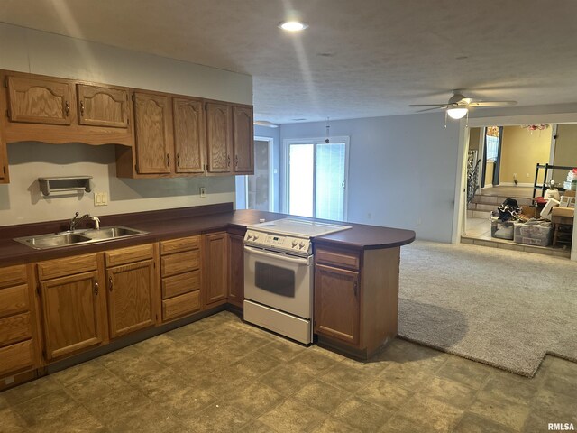 104 Mcneil St, Energy, IL 62933 - kitchen featuring white electric range oven, dark countertops, a peninsula, brown cabinetry, and ceiling fan