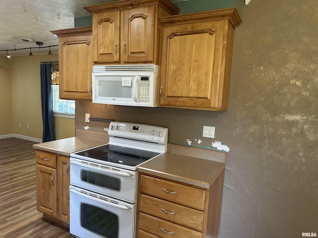 104 Mcneil St, Energy, IL 62933 - kitchen with white appliances, dark wood-type flooring, rail lighting, and brown cabinetry
