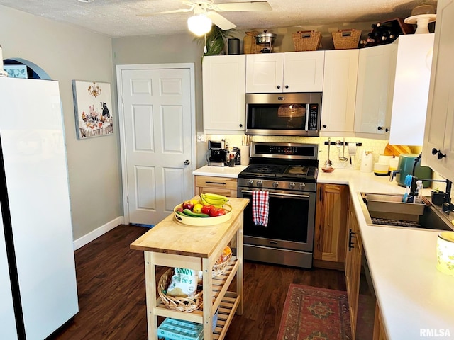 803 Butler St, Metropolis, IL 62960 - kitchen featuring stainless steel appliances, dark wood finished floors, light countertops, a ceiling fan, and a textured ceiling