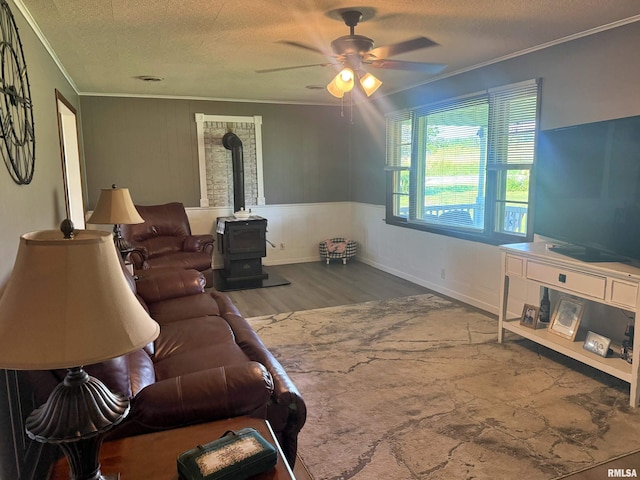 4139 Altenberger Rd, Metropolis, IL 62960 - living room with ornamental molding, a wood stove, wood finished floors, a ceiling fan, and a textured ceiling