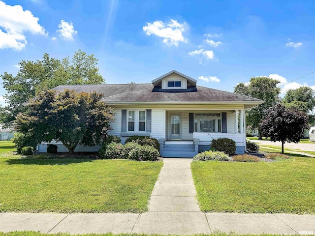 202 Flora Ave, Flora, IL 62839 - bungalow-style house with a front yard, covered porch, and roof with shingles