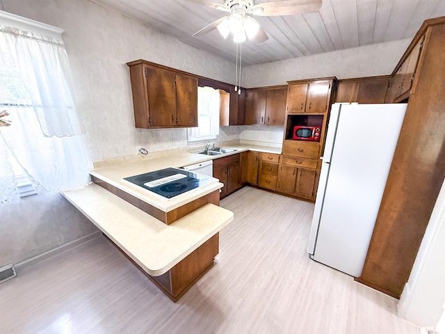 202 Flora Ave, Flora, IL 62839 - kitchen with white appliances, a peninsula, light wood-style floors, light countertops, and a ceiling fan