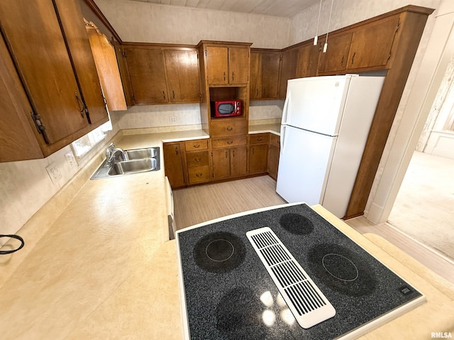 202 Flora Ave, Flora, IL 62839 - kitchen featuring freestanding refrigerator, black electric cooktop, brown cabinets, and light countertops