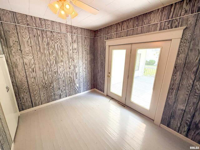 202 Flora Ave, Flora, IL 62839 - spare room featuring wood-type flooring, wood walls, and ceiling fan