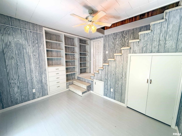 202 Flora Ave, Flora, IL 62839 - below grade area with a ceiling fan, wood finished floors, wood walls, and stairway