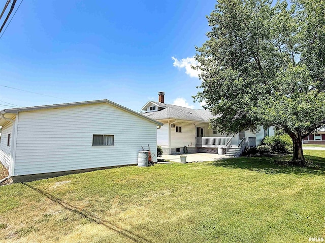 202 Flora Ave, Flora, IL 62839 - rear view of house with a patio area, a yard, and a chimney