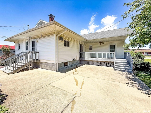 202 Flora Ave, Flora, IL 62839 - view of front facade featuring a chimney, a porch, and roof with shingles