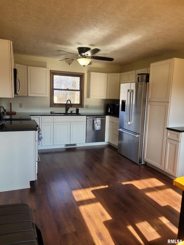 11968 E Goshen Meadows Rd, Mount Vernon, IL 62864 - kitchen featuring appliances with stainless steel finishes, a textured ceiling, dark countertops, white cabinetry, and a ceiling fan