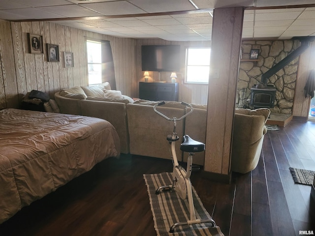 11968 E Goshen Meadows Rd, Mount Vernon, IL 62864 - bedroom with a paneled ceiling, a wood stove, wood walls, and dark wood-style floors