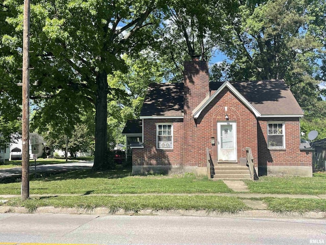 300 N Oakland Ave, Carbondale, IL 62901 - view of front facade featuring entry steps, a chimney, brick siding, and a front lawn
